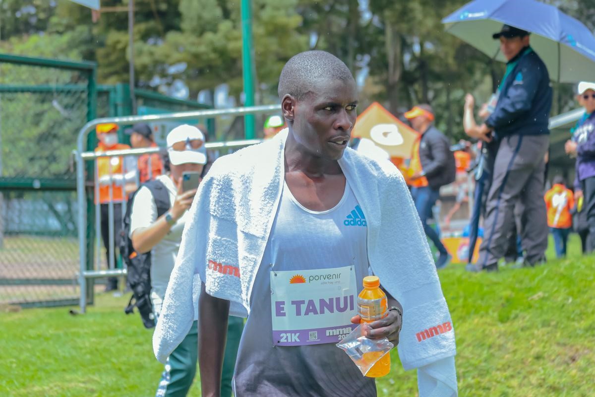 Hombre hidratando después de correr la media maratón de bogotá 2023